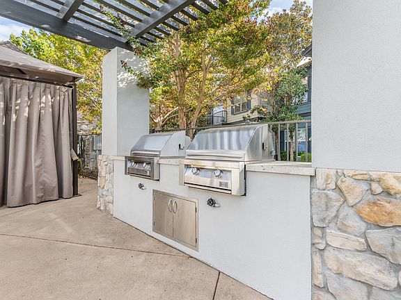 We offer two stainless steel barbecue grills on the side of a patio