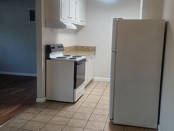 Tile floors in kitchen and bath, laminate in living area and hall, carpet in bedrooms.