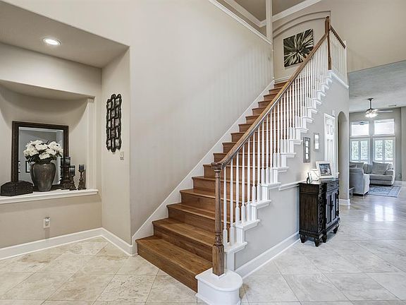 STRIKING 2 STORY FOYER OPENS TO THE FORMAL LIVING, DINING AND DEN/ KITCHEN IN THE BACKGROUND.