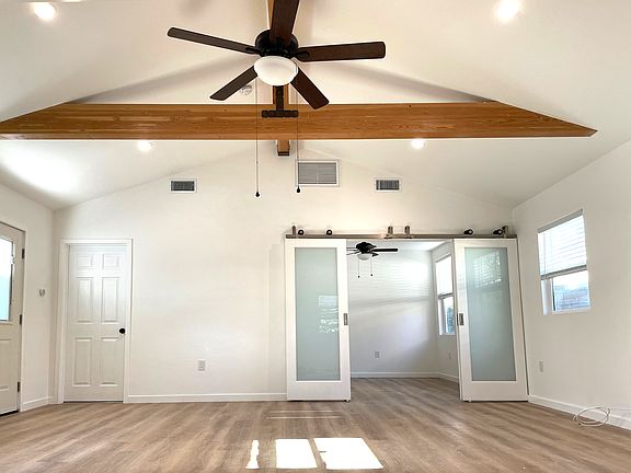 The great room with bed room entrace (smoked glass modern barn doors) and the bathroom door to the left.