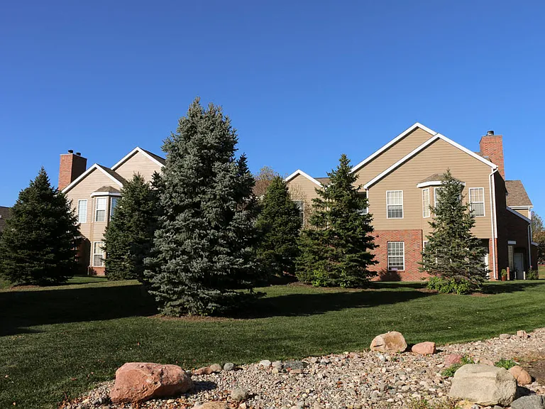 Live surrounded by nature with beautifully maintained green space, mature evergreens, and peaceful views.
