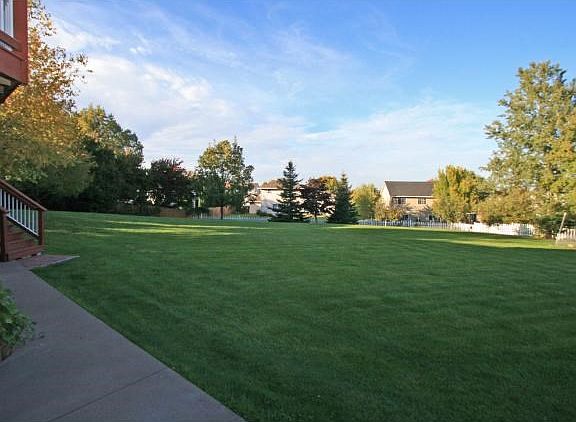Check out this amazing backyard! Surrounded by a white picket fence, amazing gardens, fruit trees and unlimited area for playtime!