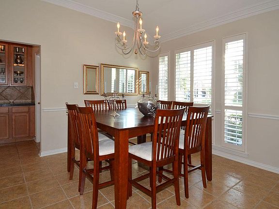 Formal dining to the right off the foyer... Plantation Shutters ...Note the built-in "Butler's Pantry" in the background... High ceiling... Crown molding...