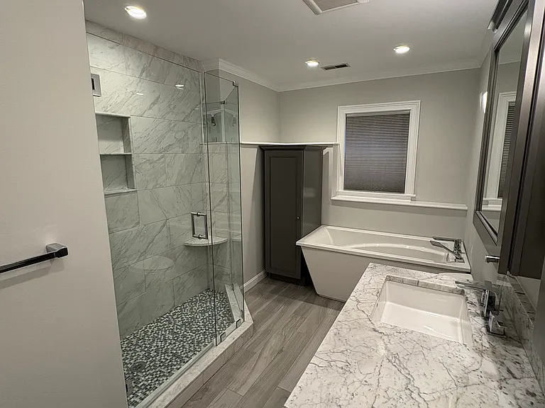 Master bathroom with heated floors, double vanity, soaker tub, and glass shower