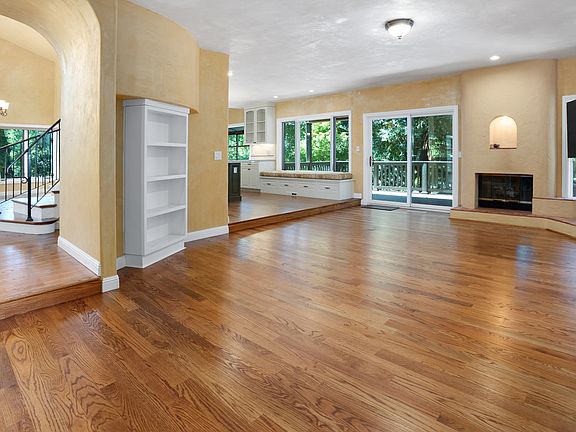 Family room with fireplace looking into entry, kitchen and outdoor deck