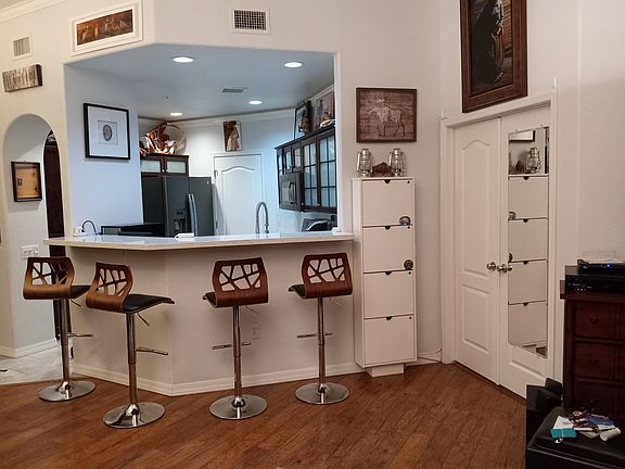 Open Floor plan with easy conversation from quartz kitchen counters, eat-in kitchen bar, dining area for 6, relaxing curved leather couch and entertainment center, along with a 2-sided fireplace.