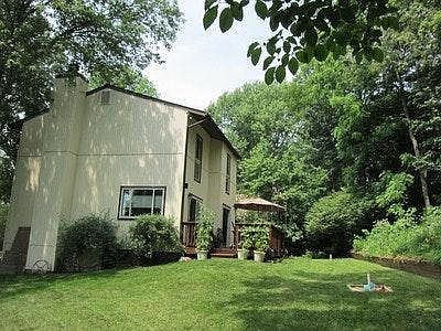 View from side of house showing yard and backs to woods.