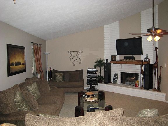 Living room with high ceilings and beautiful brick fireplace.