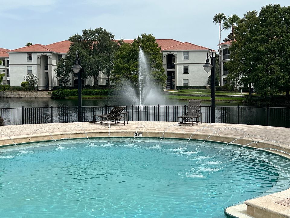 Pool area adjacent to pond and fountain. Unit is in building to the right of the photo