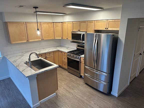 Clean and bright kitchen with LG appliances that include a refrigerator, gas stove, microwave and dishwasher. Large sink with garbage disposal.