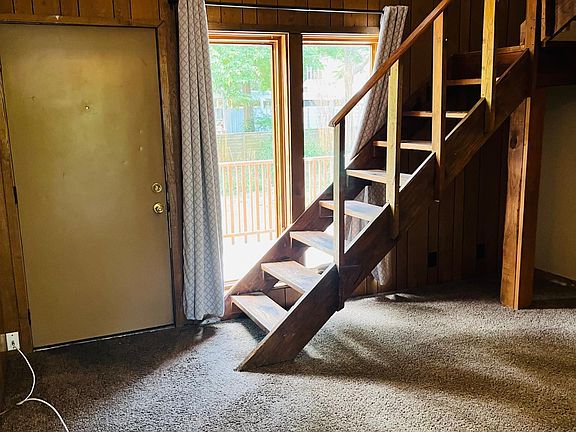 Looking from kitchen to front door, living area, and stairs that lead to the second floor living area, bedroom, bathroom, and washer & dryer.
