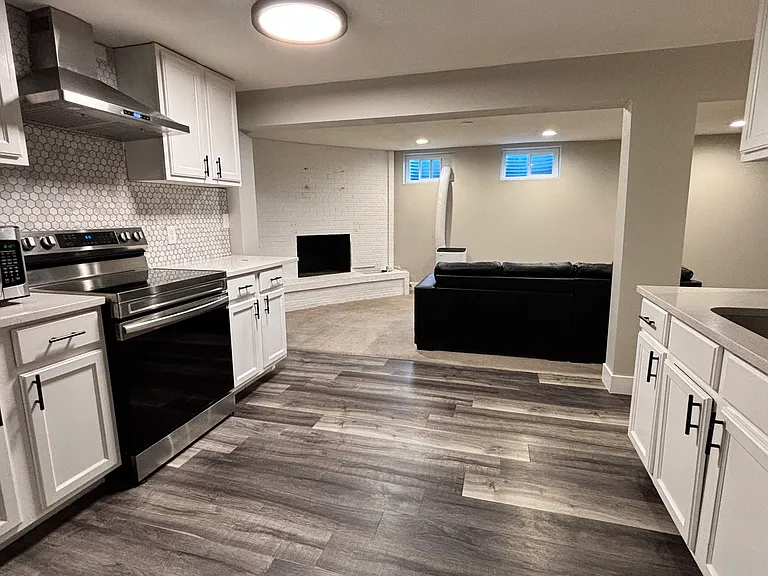 Open kitchen area with modern appliances and new hood vent