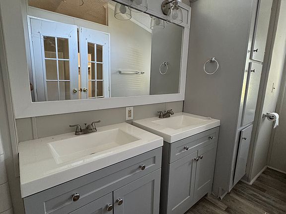 Double vanity with double sinks and overhead window along with tile tub