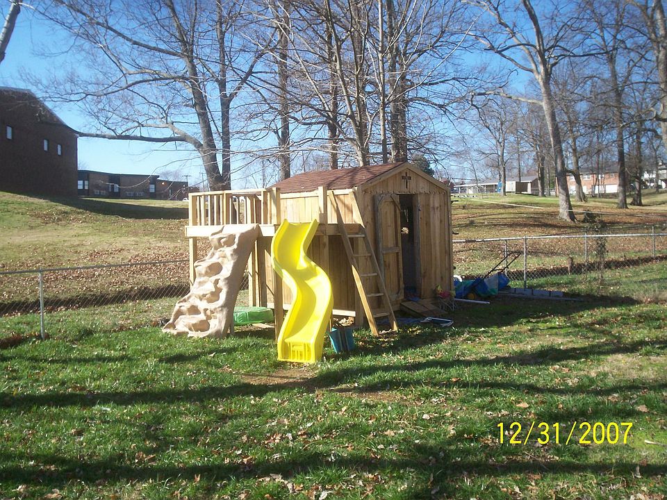 Kids will love outdoor playhouse with slide, deck, and rockwall.