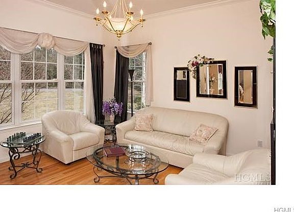 The formal living room features crown molding, a triple window and is wired with a speaker, part of 