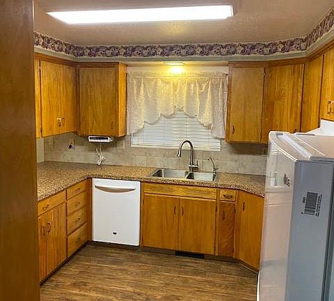 Kitchen. The flooring is wood-look vinyl plank. The window looks out over the rear patio. Lots of storage.