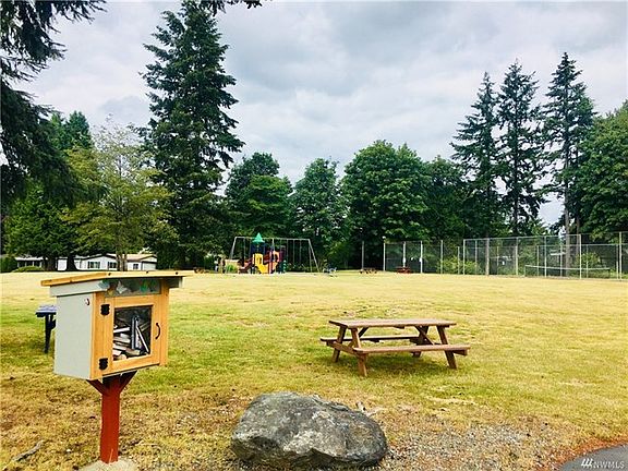 Community park with picnic tables, tennis courts, and a little free library