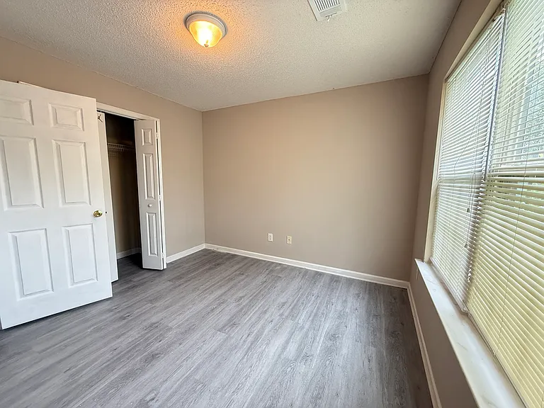 Alternative view of the third bedroom showing the room's great layout and functional closet doors.