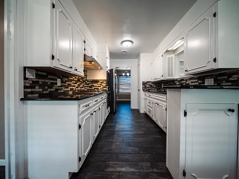 Kitchen with white cabinets, plenty of storage, and modern fixtures