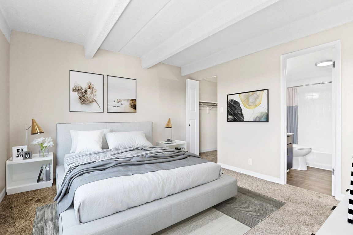 Bright and inviting bedroom with exposed beam ceiling and soft neutral palette