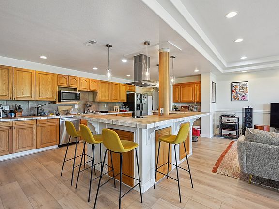 Oversized kitchen with stainless steel appliances, and large island with plenty of counter space and storage.