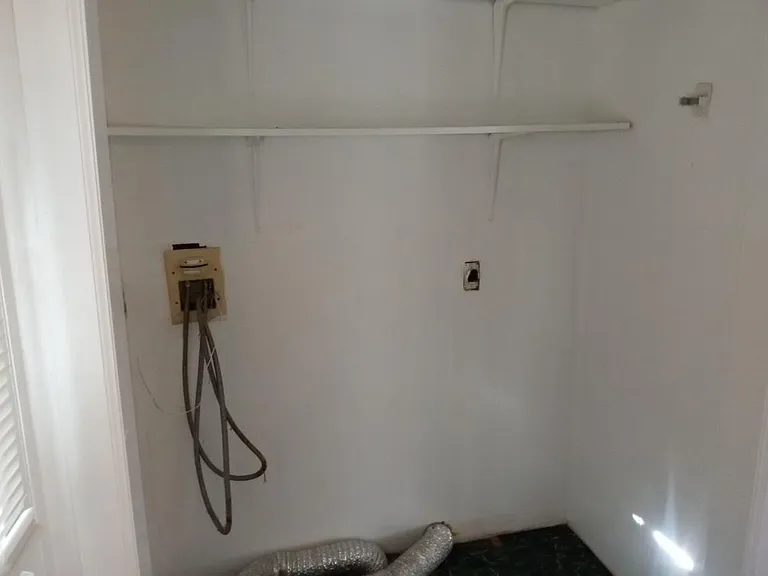 Laundry hook up in back hall closed and shelves