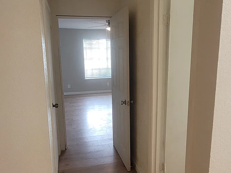 Entrance from kitchen/dining space to main/living room, bathroom (right door), and cupboard under stairs with boiler (left door)