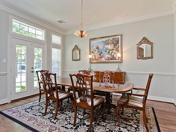 French doors & windows with transoms flood the formal dining room with natural light. Wainscoting an