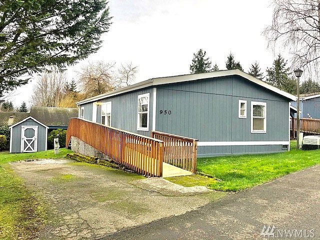 Convenient wood ramp up to front door, 2-car driveway and matching storage shed