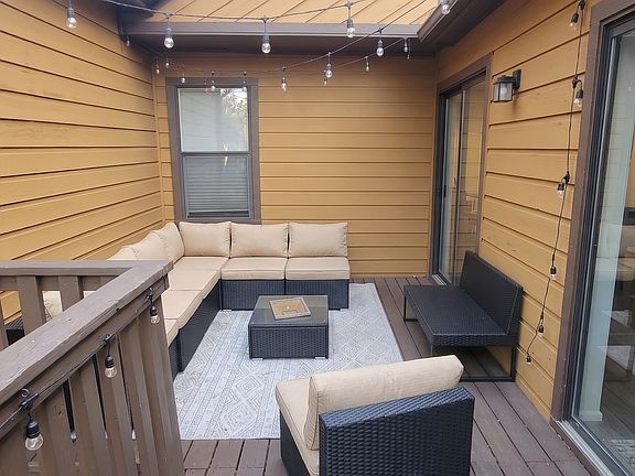 Enjoy a seamless indoor-outdoor flow with dual sliding door access from both the kitchen and primary bedroom to your private deck, complete with included string lights for the perfect evening ambiance.