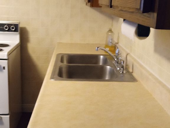 Opposite side of kitchen (cabinets, sink and counter)