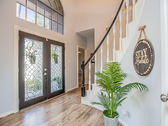 Spiral staircase, gorgeous doors and two-story entry offer an enthusiastic WOW! Beautiful natural light cascades into this foyer.