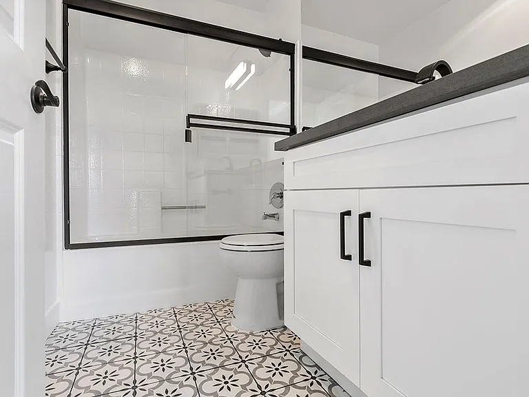 White bathroom with shower, tub, and tiled floor.