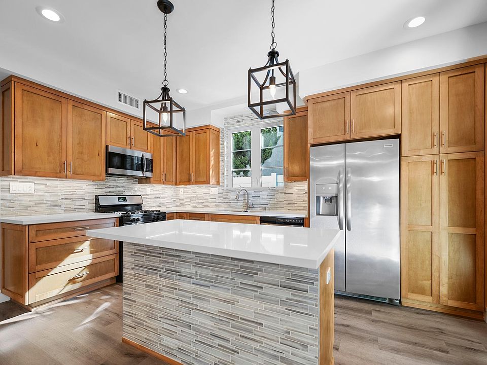 Beautiful tiled back splash with Breakfast Bar, Stainless Steel appliances and custom wood cabinets, open layout. First floor Kitchen!