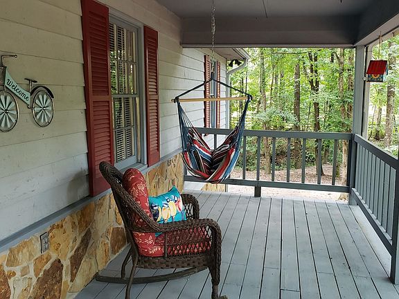 Great space for lounging rain or shine is on the large covered front porch. The rocker and hammock are perfect for relaxing.