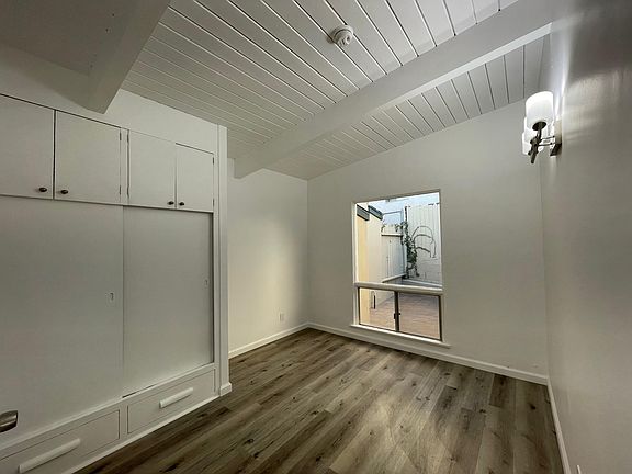 Bedroom + closet with view of private back patio