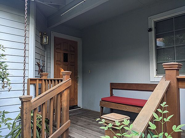 Front deck and door. Front deck nicely maintained, and features hand-made bench. Fun for Halloween decorating!