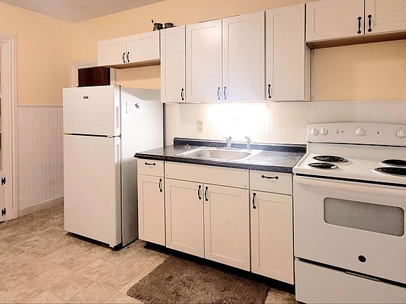Bright, attractive kitchen includes refrigerator and stove/oven.