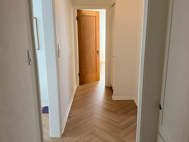 long hallway separating the two bedrooms with bathroom in center