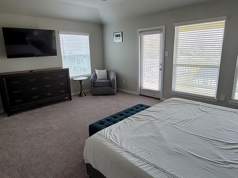 Large primary bedroom with private balcony that overlooks front of home