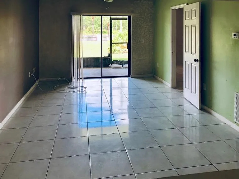 SPACIOUS LIVING ROOM WITH PATIO OUT TO POOL. TILE FLOOR.