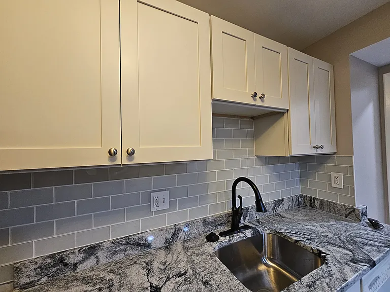 Brand new moonlight granite countertops, French gray subway tile backsplash and custom white cabinets