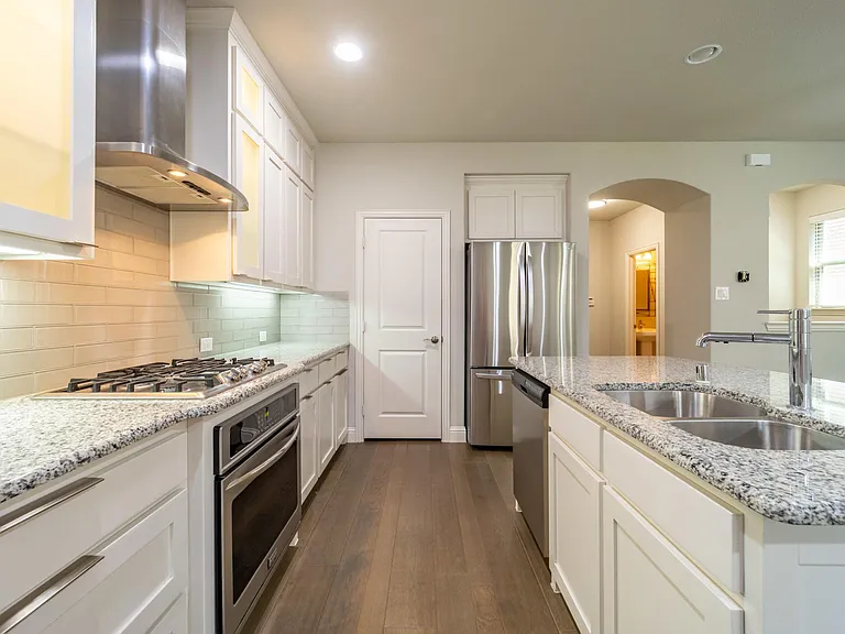 Lighted cabinets with frosted glass accent this kitchen beautifully