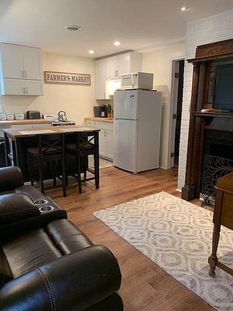 Combined kitchen, eating area and living room with electric fireplace.