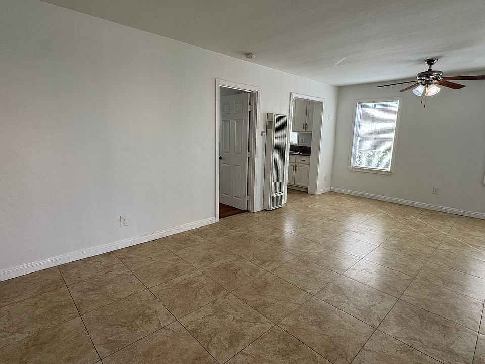 A look at the living room as you walk in and the doors to the bedroom and kitchen.
