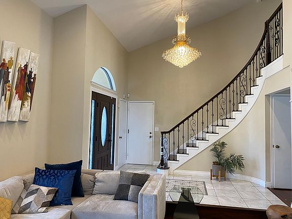 Grand entry with formal, chandelier, elegant staircase, entry tile mosaic and wooden flooring all across