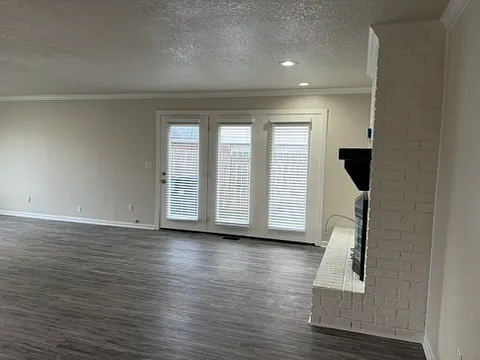 View of living room with fireplace on right. Doors lead to outside yard.