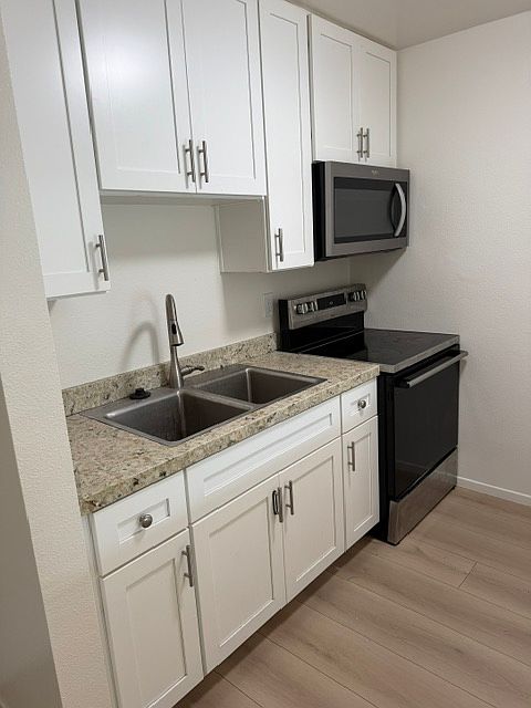 Kitchen with beach style cabinets, granite, oven/stove with microwave, lots of storage