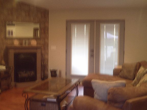left side of livingroom w/fireplace and 3 sets of frenchdoors