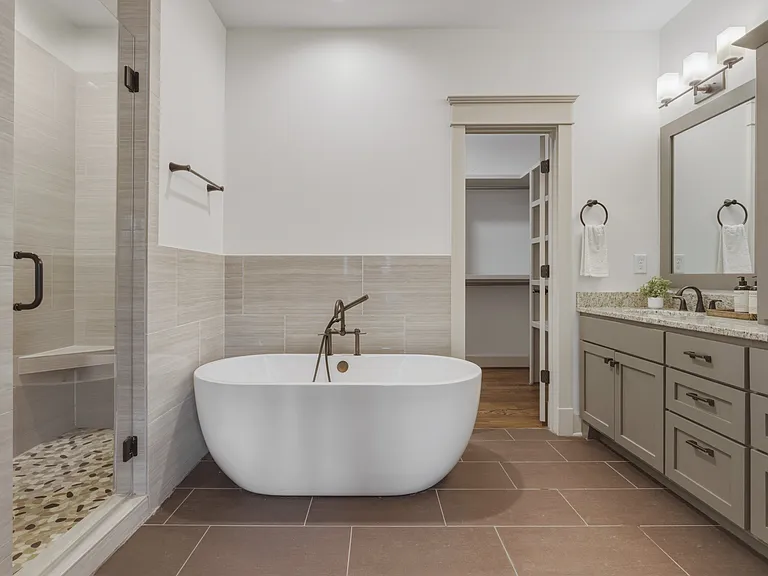Primary bathroom attaches to the primary suite. Enjoy a double vanity with an extra cabinet for storage, soaking tub, and standing shower.